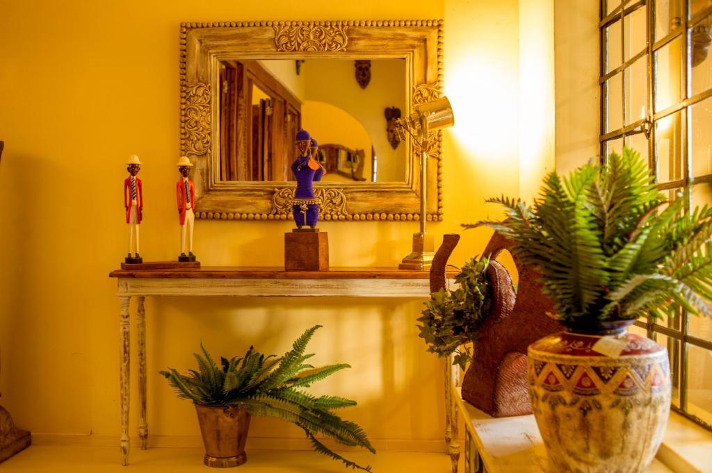 a room with a mirror and figurines on a fireplace at Villa Kololo in Kampala