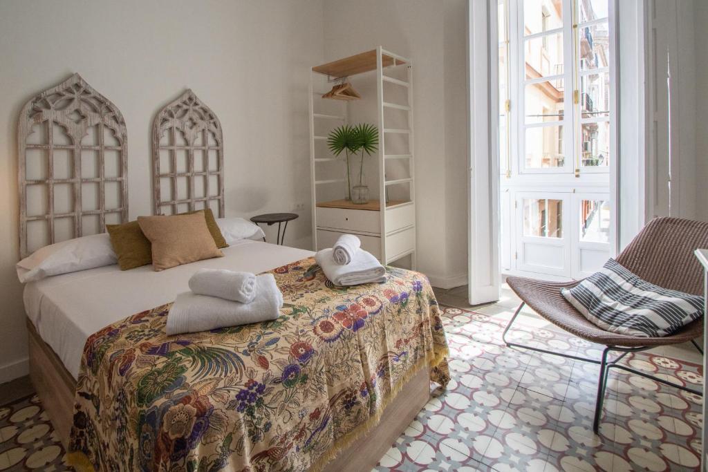 sypialnia z łóżkiem i ręcznikami w obiekcie Apartamentos Las Musas de Cadiz w Kadyksie