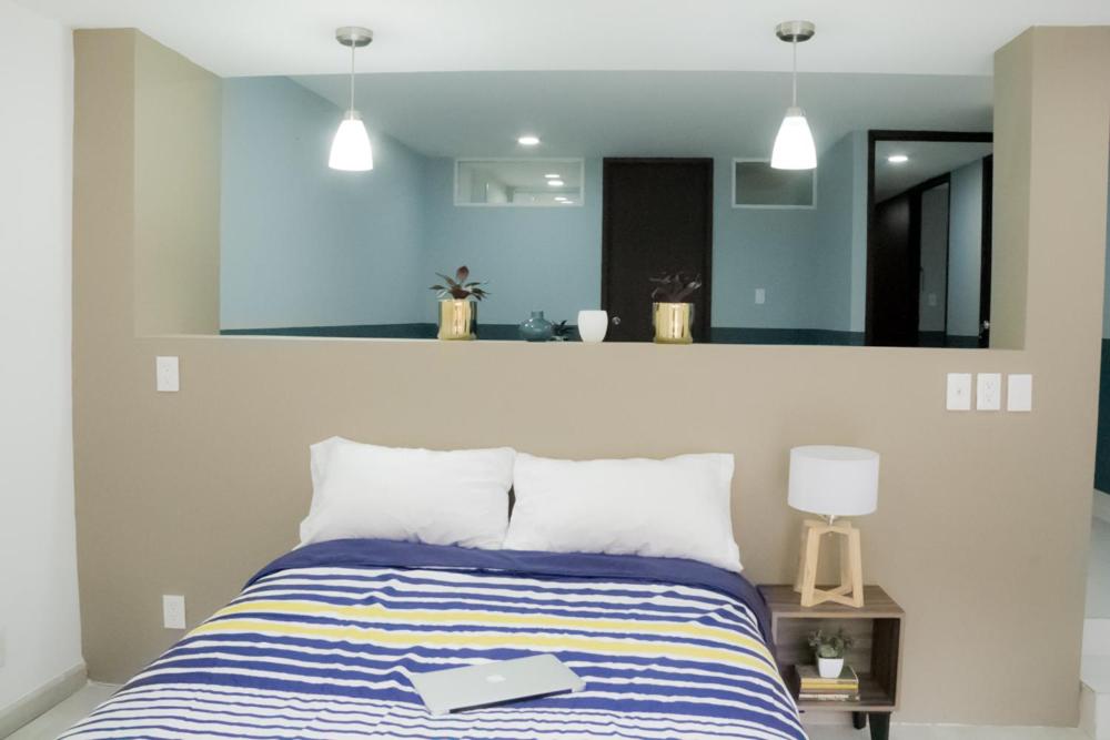 A centered view presents the bed beneath pendant lights and a long half-height divider.