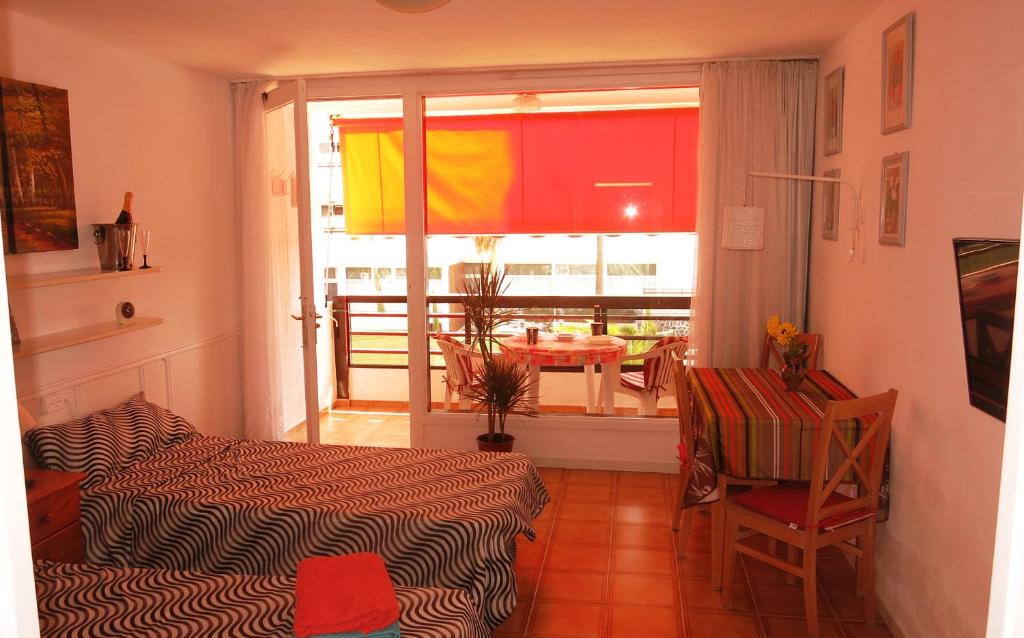 a room with a bed and a window with a table at Studio in perfect location in Playa de las Americas