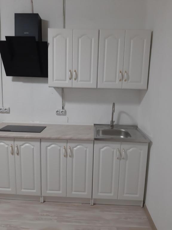 a kitchen with white cabinets and a sink at Смарт квартира in Odesa