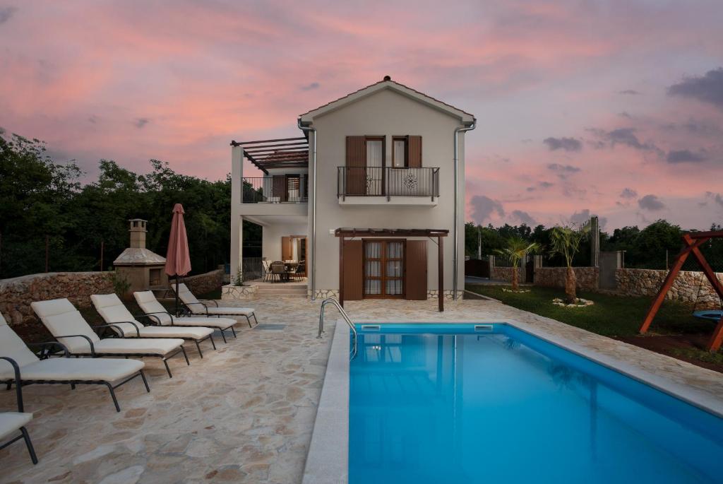 a villa with a swimming pool in front of a house at Villa Marko in Kras