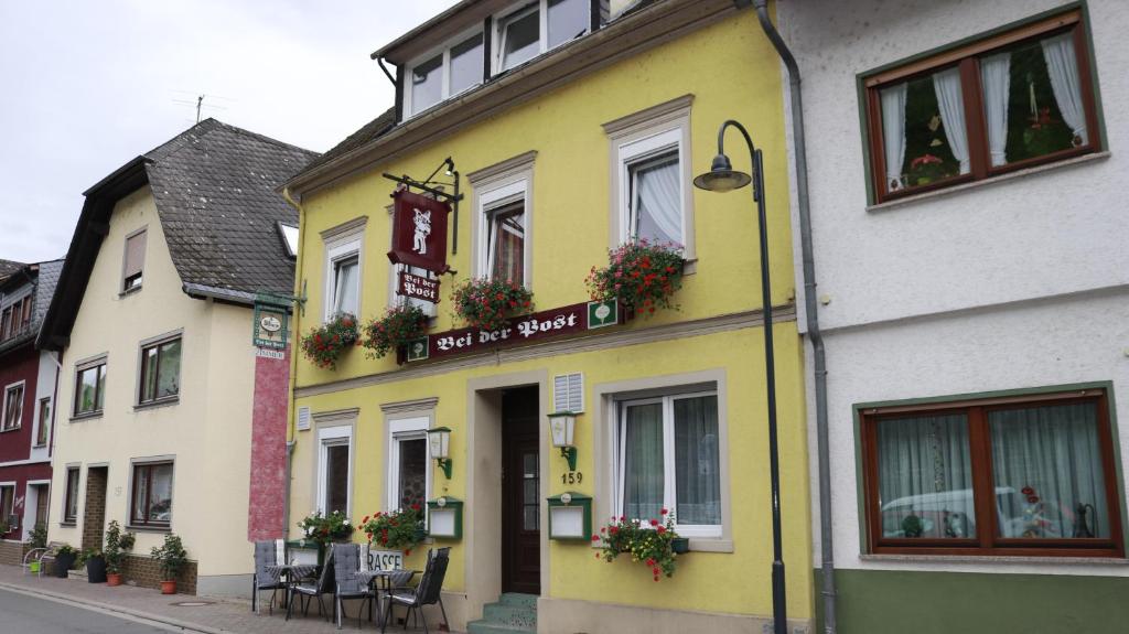 a yellow and white building on a street at Pension Bei der Post in Bacharach