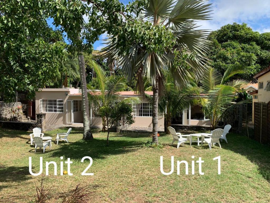 a yard with chairs and a table in front of a house at Whynot Mauritius in Grand Gaube