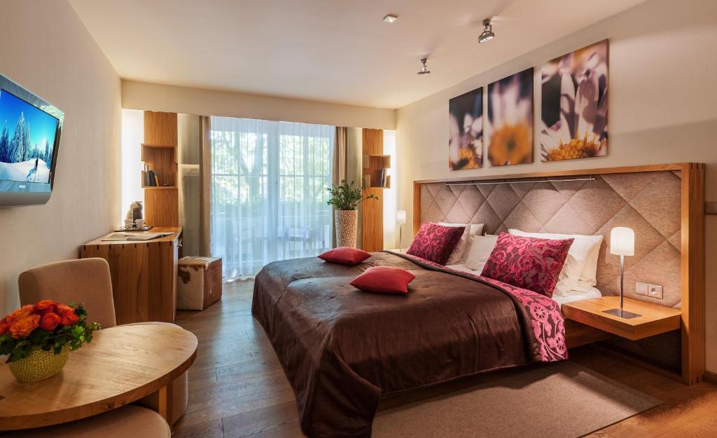 上阿瑪高的住宿－馬克西米利安酒店，一间卧室配有一张大床和一张桌子