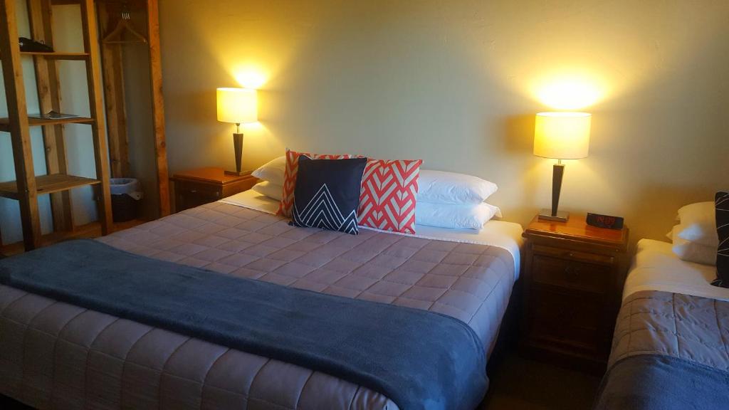 two beds in a room with two lamps on tables at Ski Time in Methven