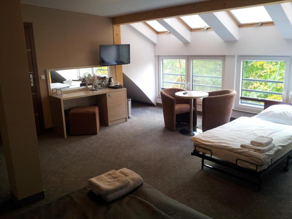 Un dormitorio con una cama, un escritorio y un espejo. en Willa Plażowa, en Międzyzdroje