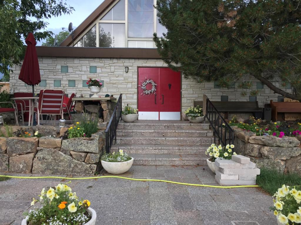 a house with a red door and stairs with flowers at The Old Church B&B in Warner