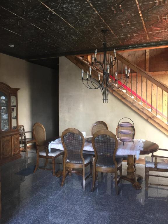 a dining room with a table and chairs and a staircase at The Old Church B&B in Warner