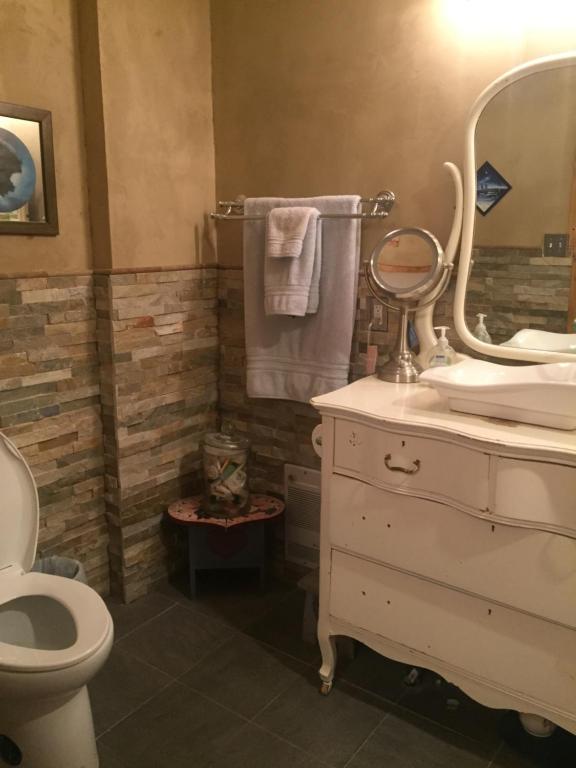 a bathroom with a sink and a toilet and a mirror at The Old Church B&B in Warner