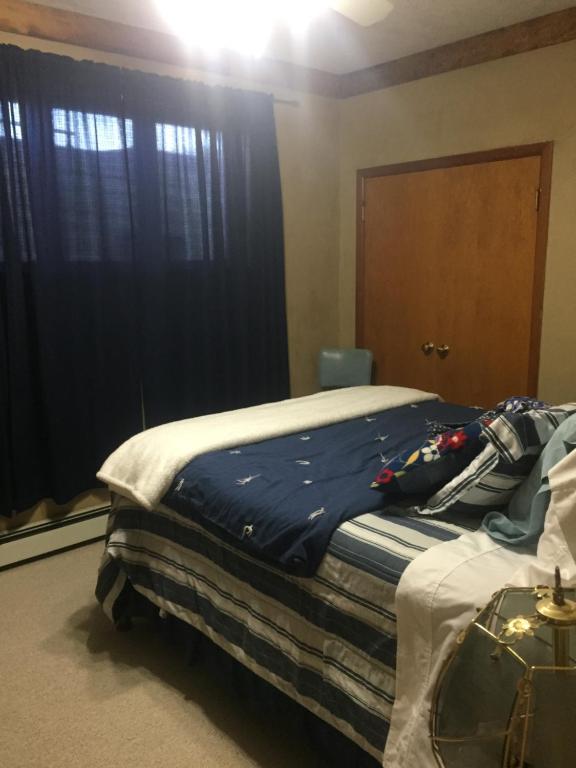 a bedroom with a bed with a blue blanket on it at The Old Church B&B in Warner