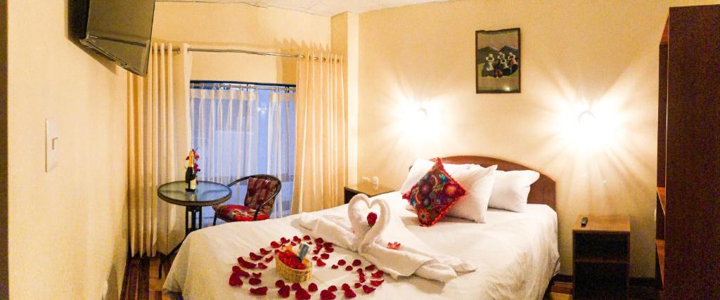 Una habitación de hotel con una cama con toallas. en Hawka Inka Hostal - Cusco en Cusco