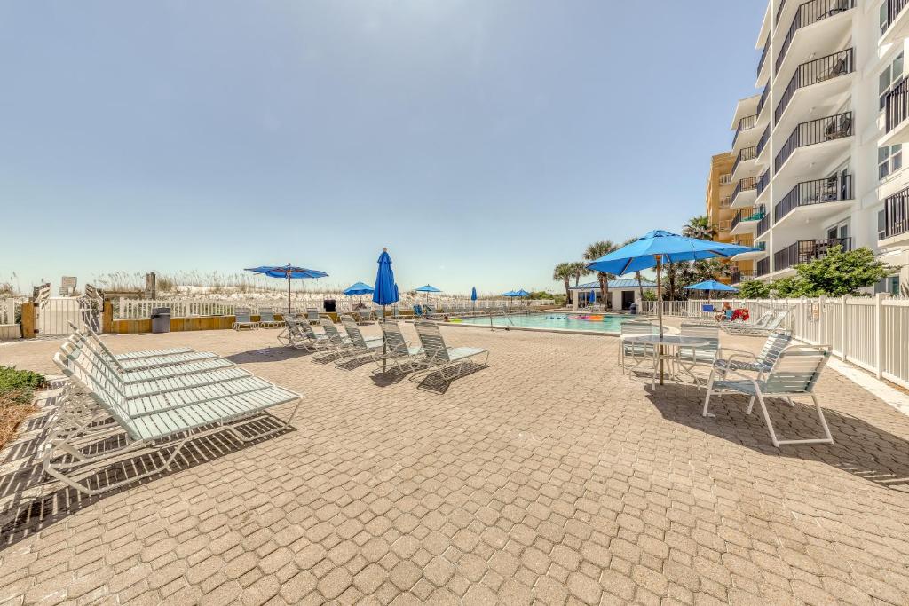 a group of chairs and umbrellas next to a pool at Sea Oats in Fort Walton Beach