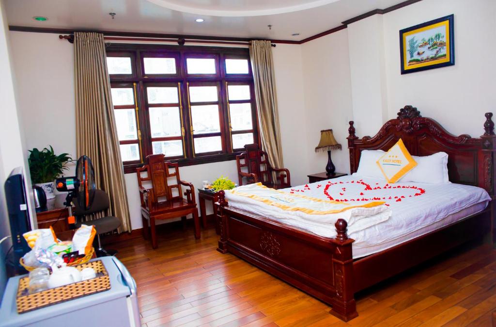 um quarto com uma cama, uma secretária e uma janela em Hotel Kally Saigon em Ho Chi Minh