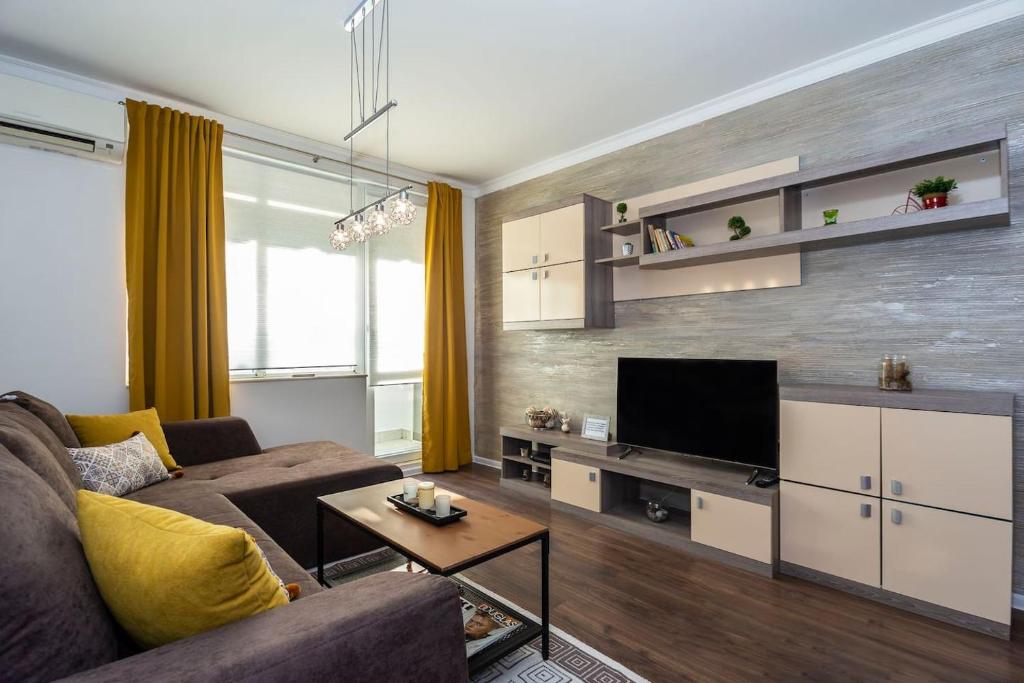 a living room with a couch and a flat screen tv at Stunning location and views!Foothills of Old town! in Plovdiv