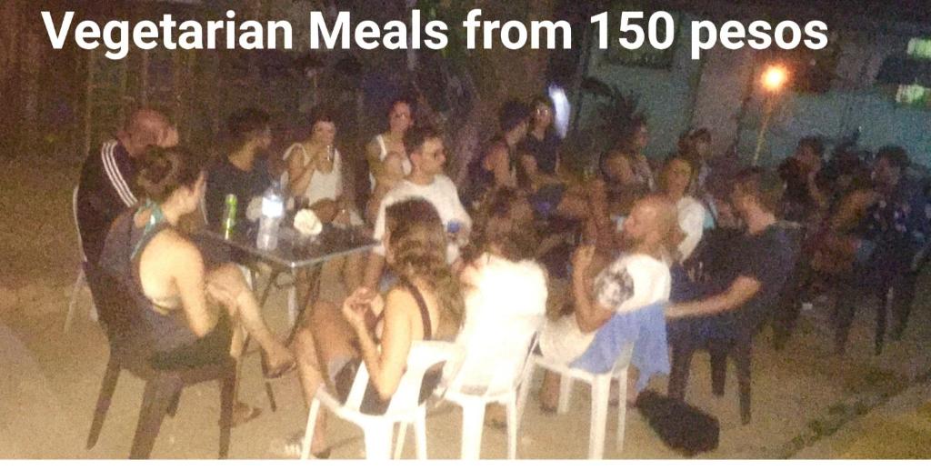 un grupo de personas sentadas en sillas en una fiesta en Hub Backpackers Hangout, en Corón