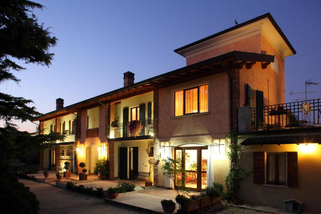 un gran edificio de ladrillo con luces encendidas en Le Vigne di Adamo, en Volta Mantovana