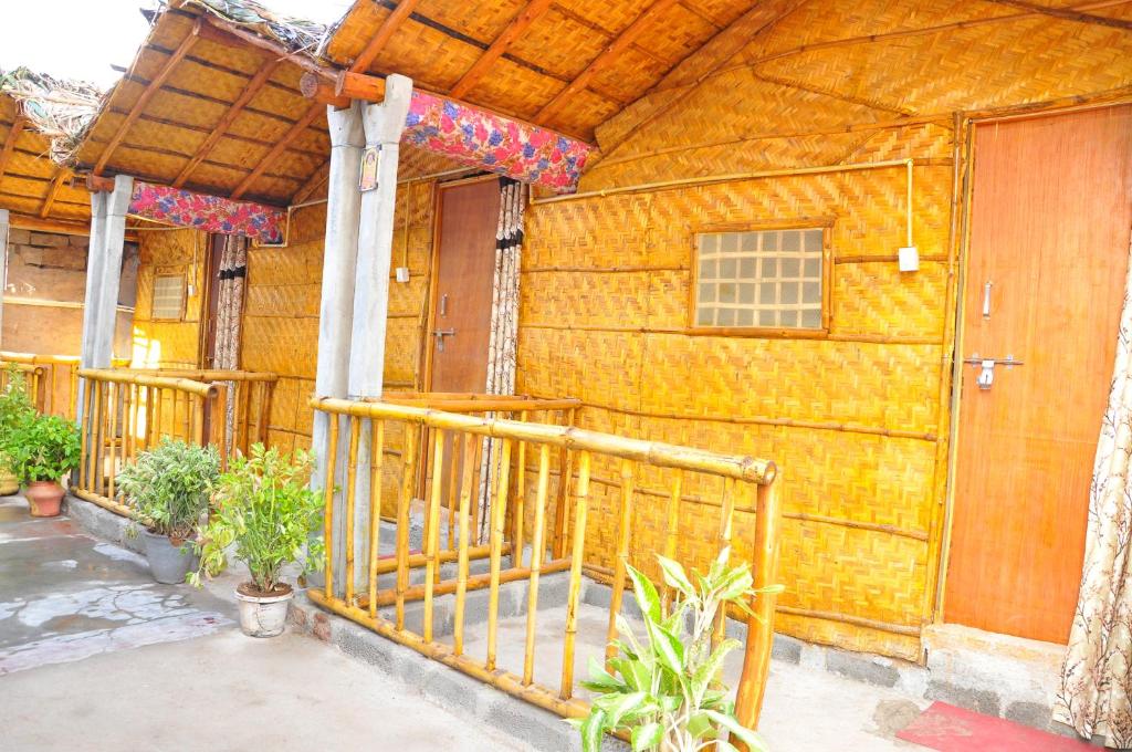 un edificio de madera con porche y puerta en Khushi Cottage, en Hampi