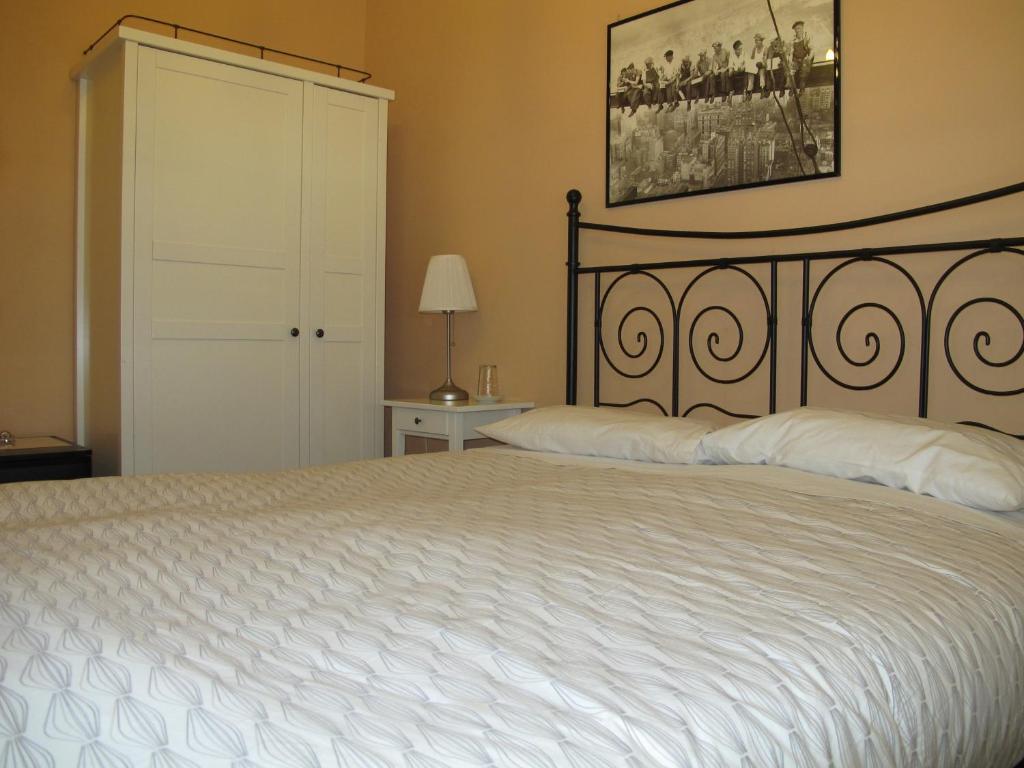 - une chambre avec un grand lit et un couvre-lit blanc dans l'établissement Santa Croce, à Rome