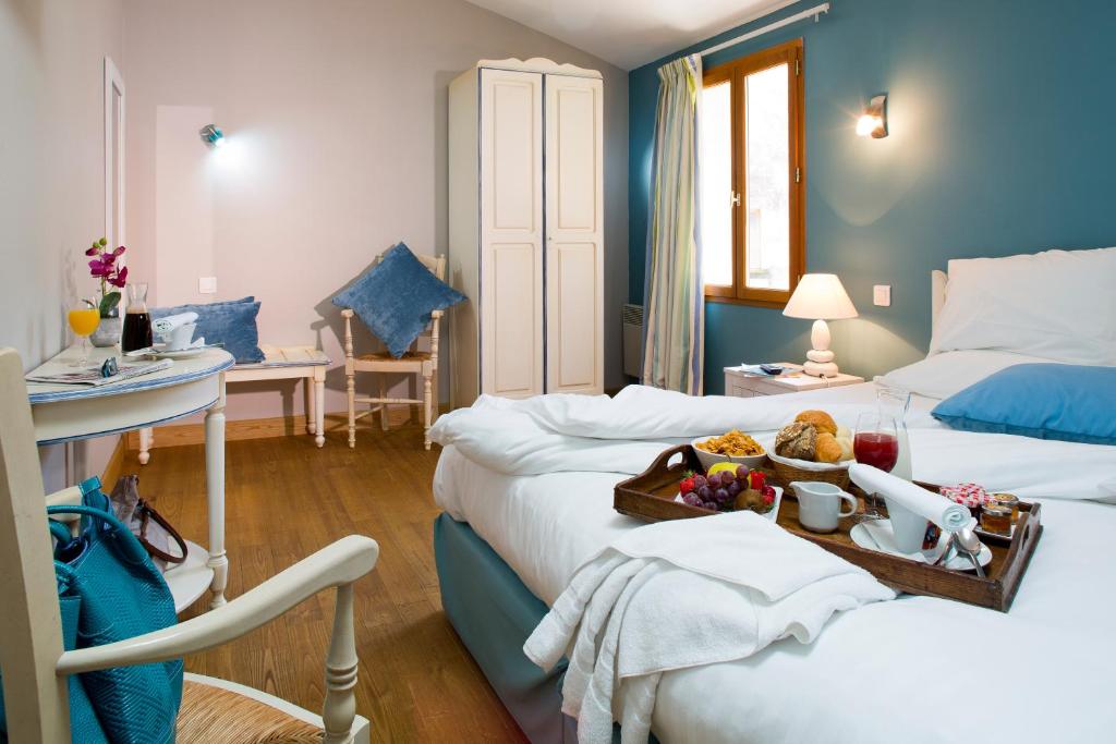a hotel room with two beds with a tray of food at Logis hotel les flots bleus in Beaulieu-sur-Dordogne