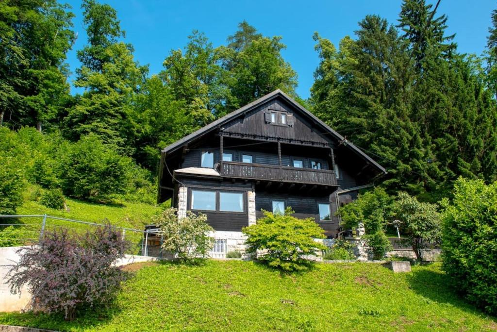 une maison en bois sur une colline avec des arbres dans l'établissement Gorgeous Chalet, à Bled