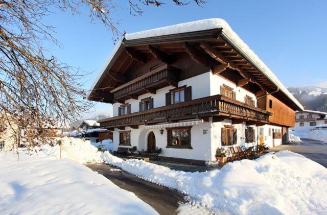 ein Haus ist mit Schnee bedeckt mit Schnee bedeckt in der Unterkunft Neukumhof in Westendorf