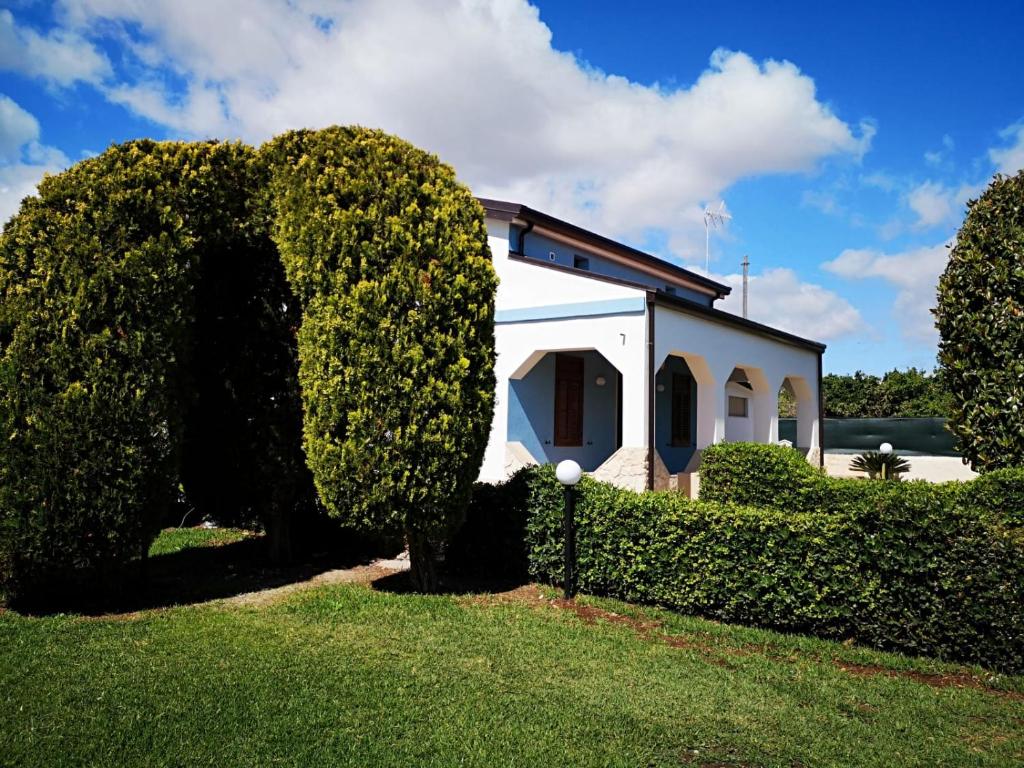 a white house with a hedge in front of it at Villa Magie del Mare in Arenella
