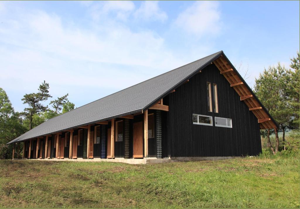 a black barn with a black roof at Oita Toranoyu in Kokonoe