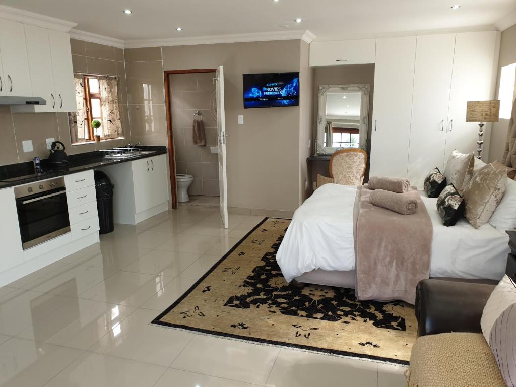 Pongola Road Self Catering Accommodation في Uitenhage: غرفة معيشة كبيرة مع أريكة ومطبخ