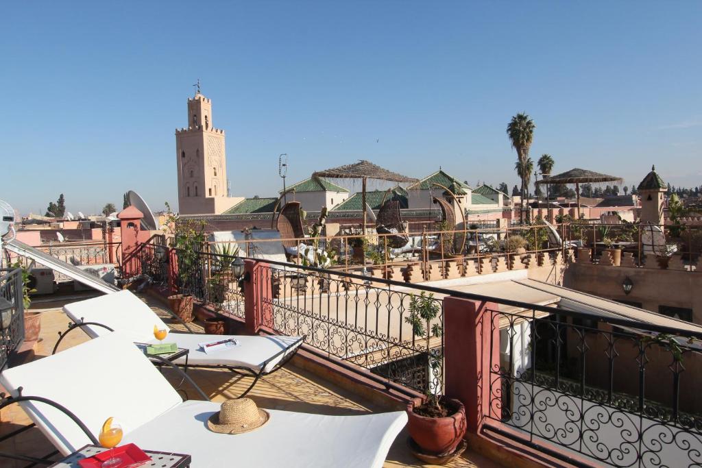 a balcony with tables and chairs on top of a building at Riad Bab Tilila in Marrakech