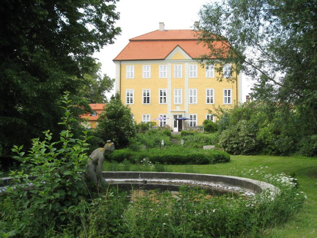 Grimmen的住宿－Jagdschloss Quitzin，一座黄色大建筑前的雕像