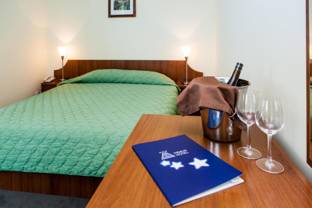 1 dormitorio con 1 cama y 1 mesa con copas de vino en Hemus Hotel Sofia, en Sofía