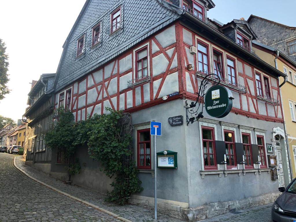 ein rot-weißes Gebäude an der Straßenseite in der Unterkunft Gasthaus Zur Weintraube in Bad Langensalza