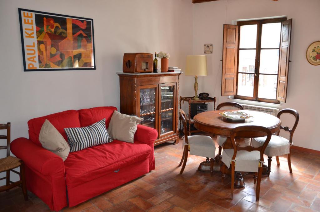 a living room with a red couch and a table at In centro in Montalcino