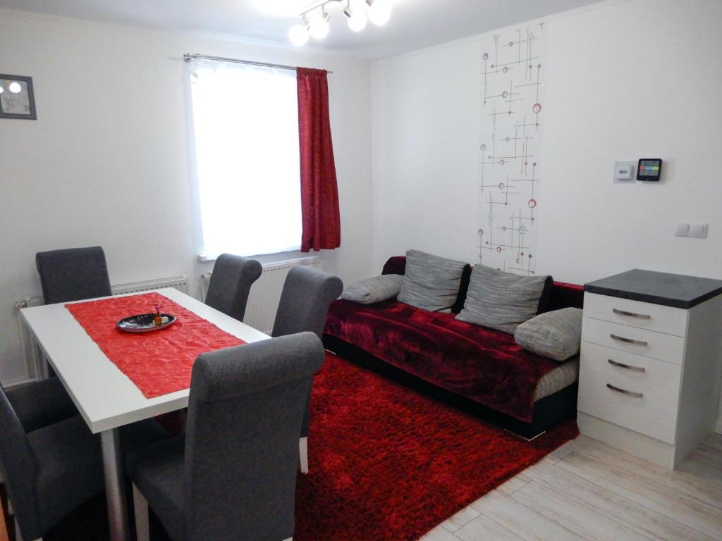 a living room with a red couch and a table at Apartment for your Holiday in Ramingstein