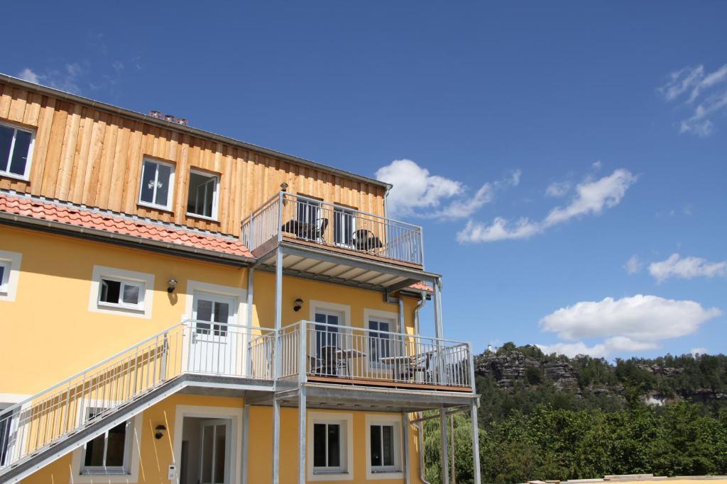 a yellow building with balconies on the side of it at Alter Gutshof Papstdorf in Papstdorf