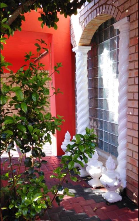 a red house with white statues in front of a door at Madida's Bed and Breakfast in Soweto
