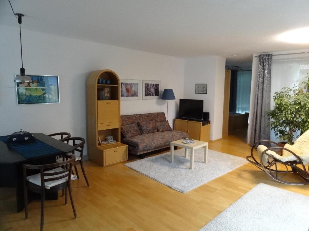 2-Zimmer Apartment Inntalblick في Ampass Unterdorf: غرفة معيشة مع أريكة وطاولة