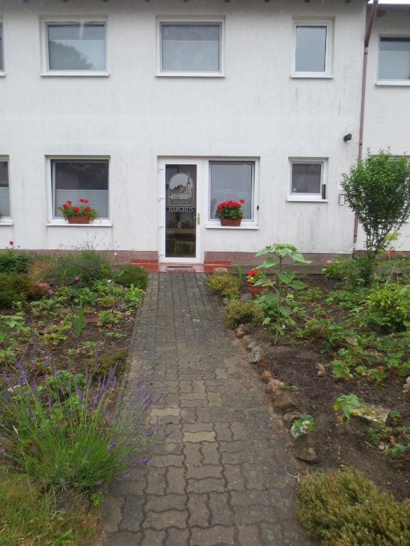 a white building with windows and flowers in front of it at Pension Barghus GmbH in Zinnowitz