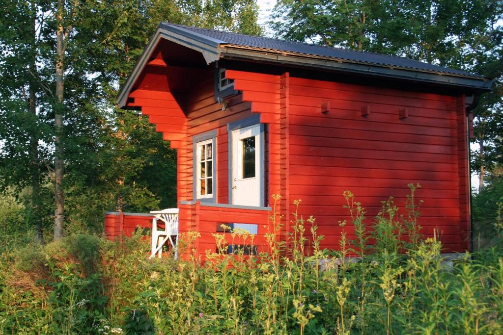 una casita roja en un campo de hierbas en Lillebo en Årjäng