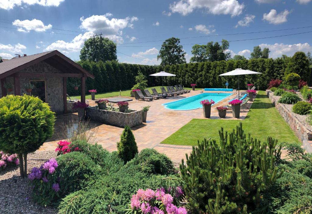 a backyard with a swimming pool and a garden at Mazurski Komfort in Piecki