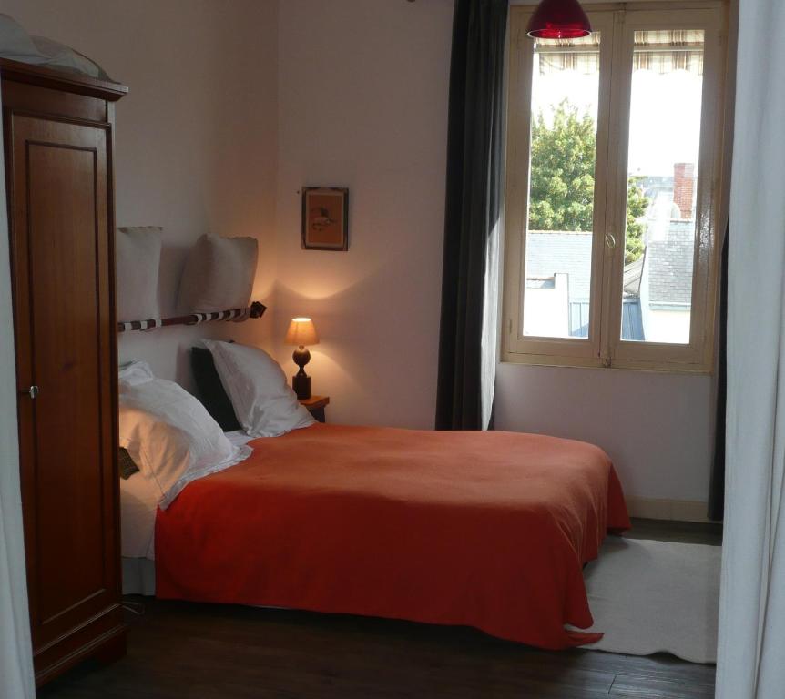 a bedroom with a bed and a window at Cosy Flat vue château Loire à velo in Saumur