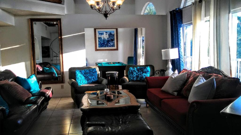 a living room with leather couches and a pool table at 3000 Sq Ft Beach and Bay Condo in St Pete Beach