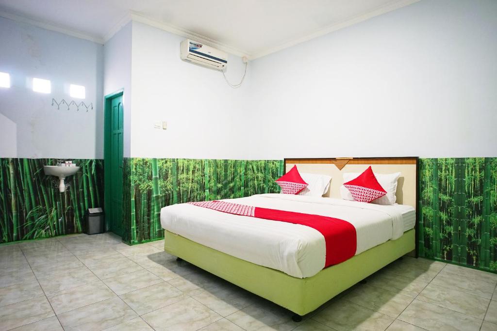 سرير أو أسرّة في غرفة في OYO 754 Nur Aziziah Guest House Syariah