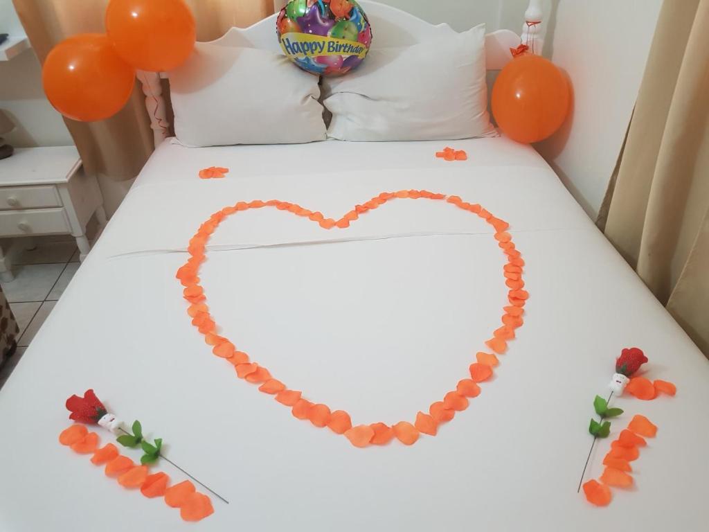 a bed with a heart made out of orange balloons at St. James Guesthouse in Roseau