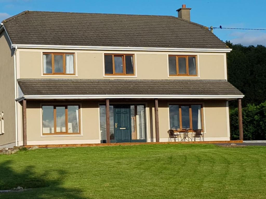 a house with a lawn in front of it at BARR AN CHNOIC HOLIDAY LETTINGS in Tipperary