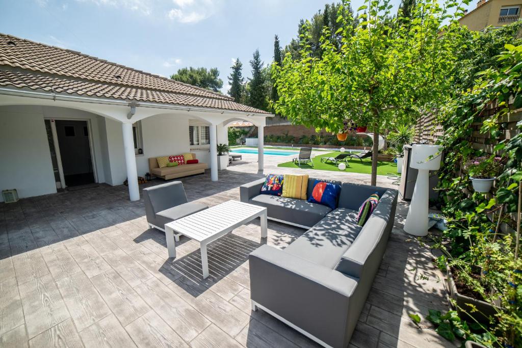 um pátio com um sofá, uma mesa e uma piscina em Jewel Home em Sant Pere de Ribes