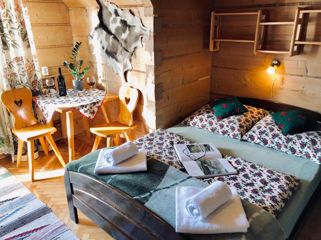 a bedroom with two beds and a table with a table at Willa Szafran - pokoje in Zakopane