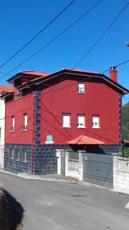 un edificio rojo al lado de una calle en La Coruxa, en Los Cabos