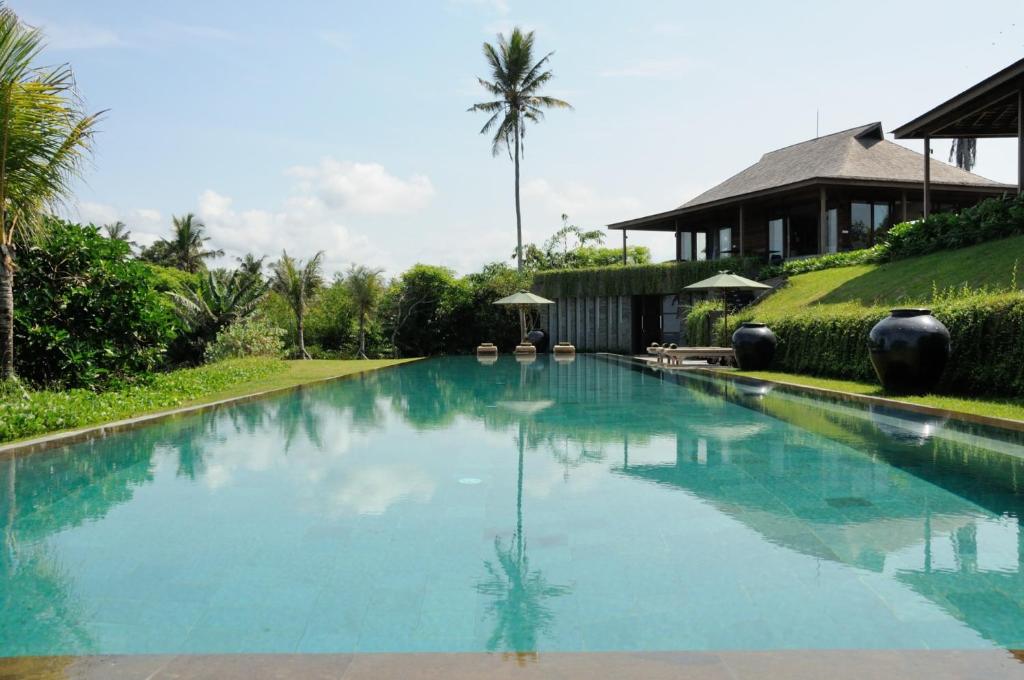 a large swimming pool in front of a house at Bulung Daya Beach Villa Retreat in Antasari
